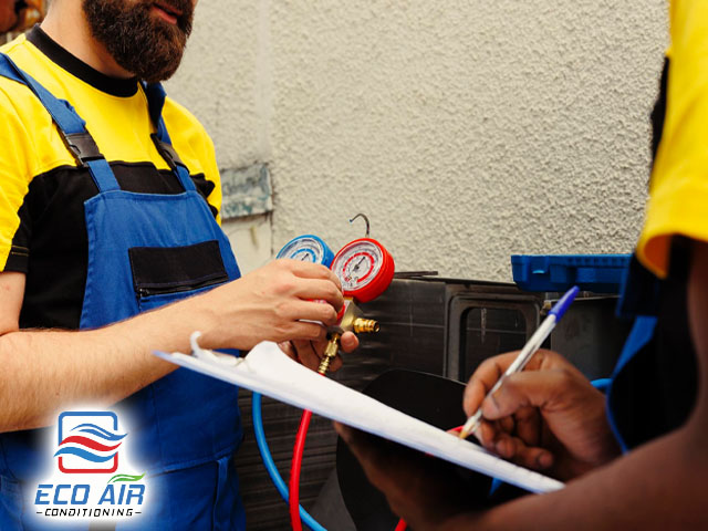 air conditioning repair workers refilling freon